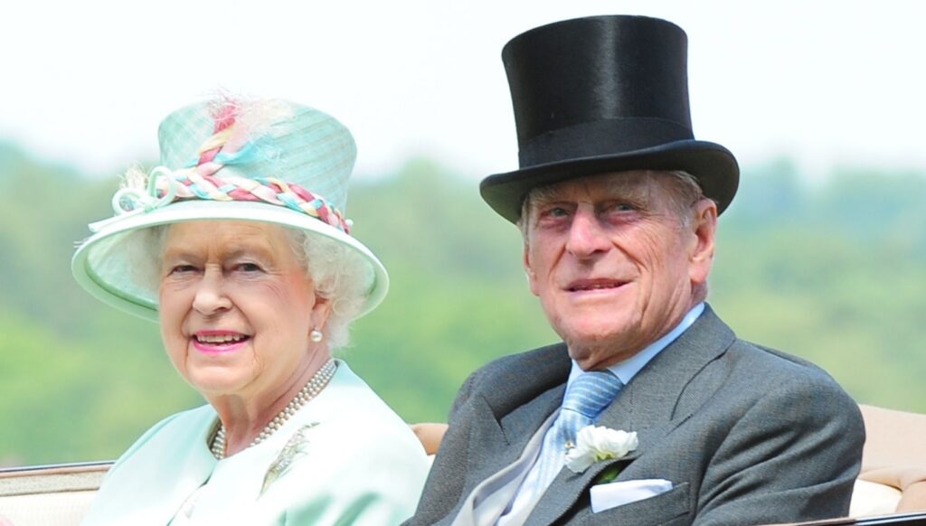 Queen Elizabeth II and Prince Philip smiling in carriage