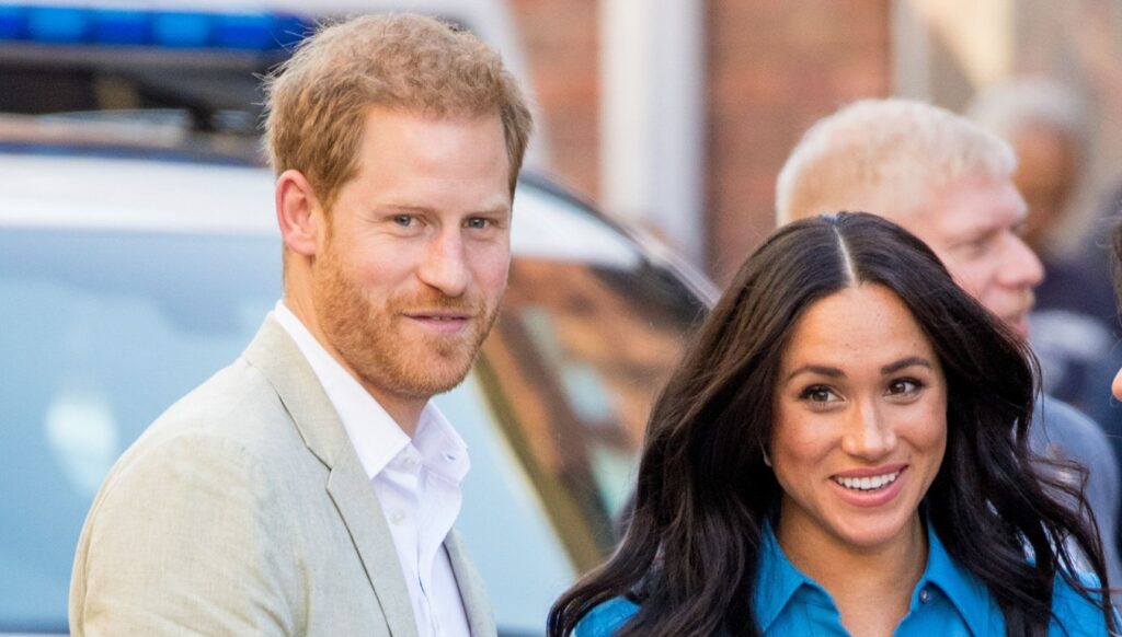 Prince Harry and Meghan Markle smiling on royal visit