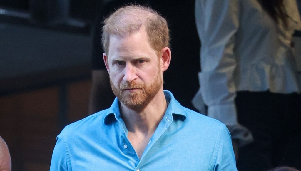 Prince Harry looking serious in blue shirt