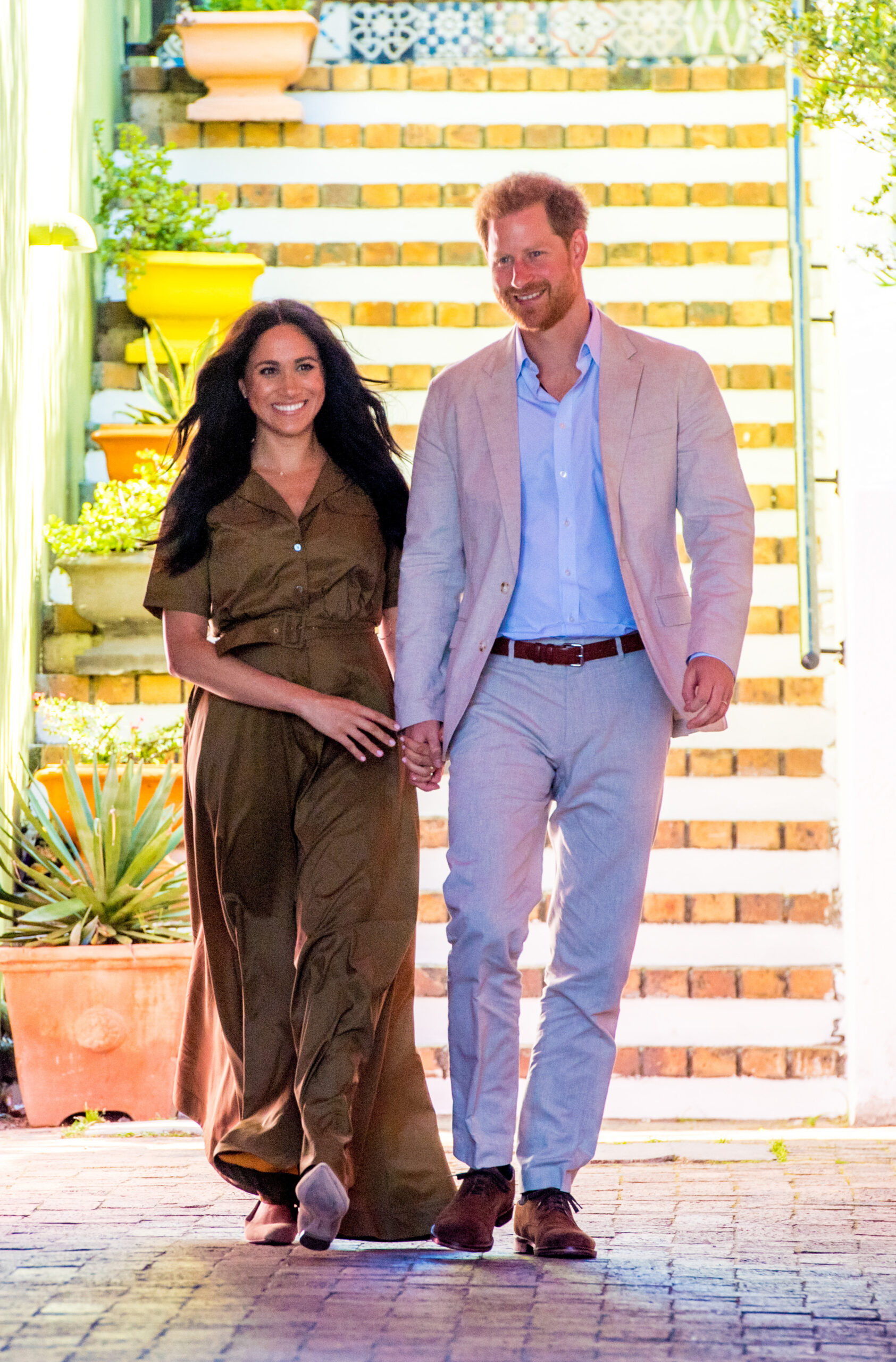 Prince Harry and Meghan Markle holding hands and walking 