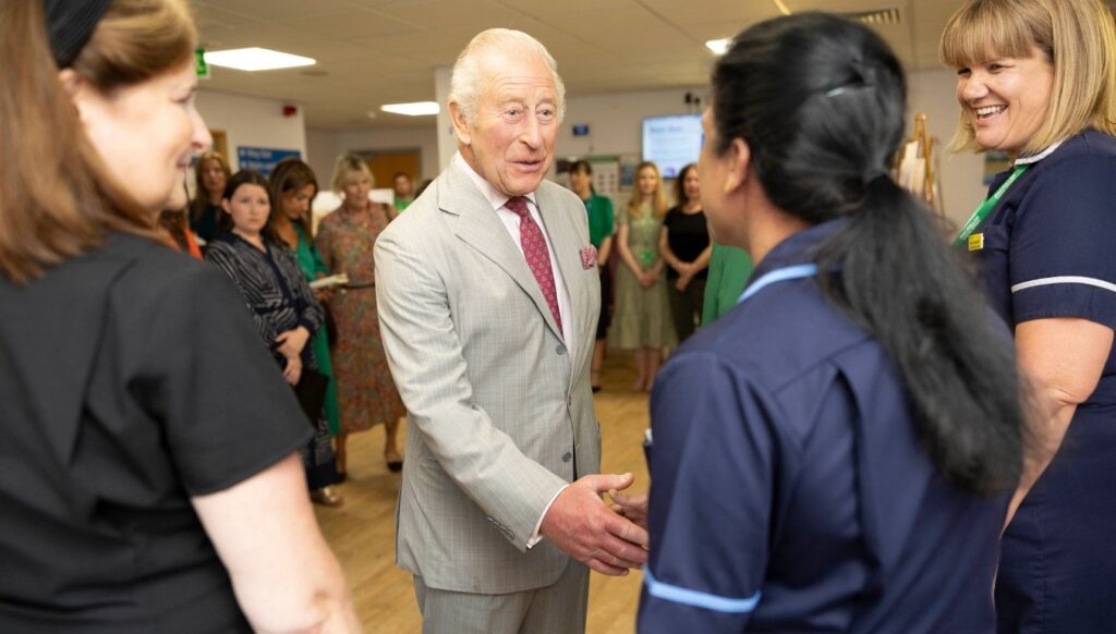 King Charles shaking hands with staff at hospital
